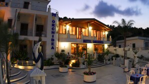 Ein Hotel namens "HOTEL ORCHIDEA" mit Innenhof, Außenbereich und einer Statue.