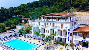 Ein Hotel mit Schwimmbad, mehreren Balkonen und Blick auf den umliegenden Wald.