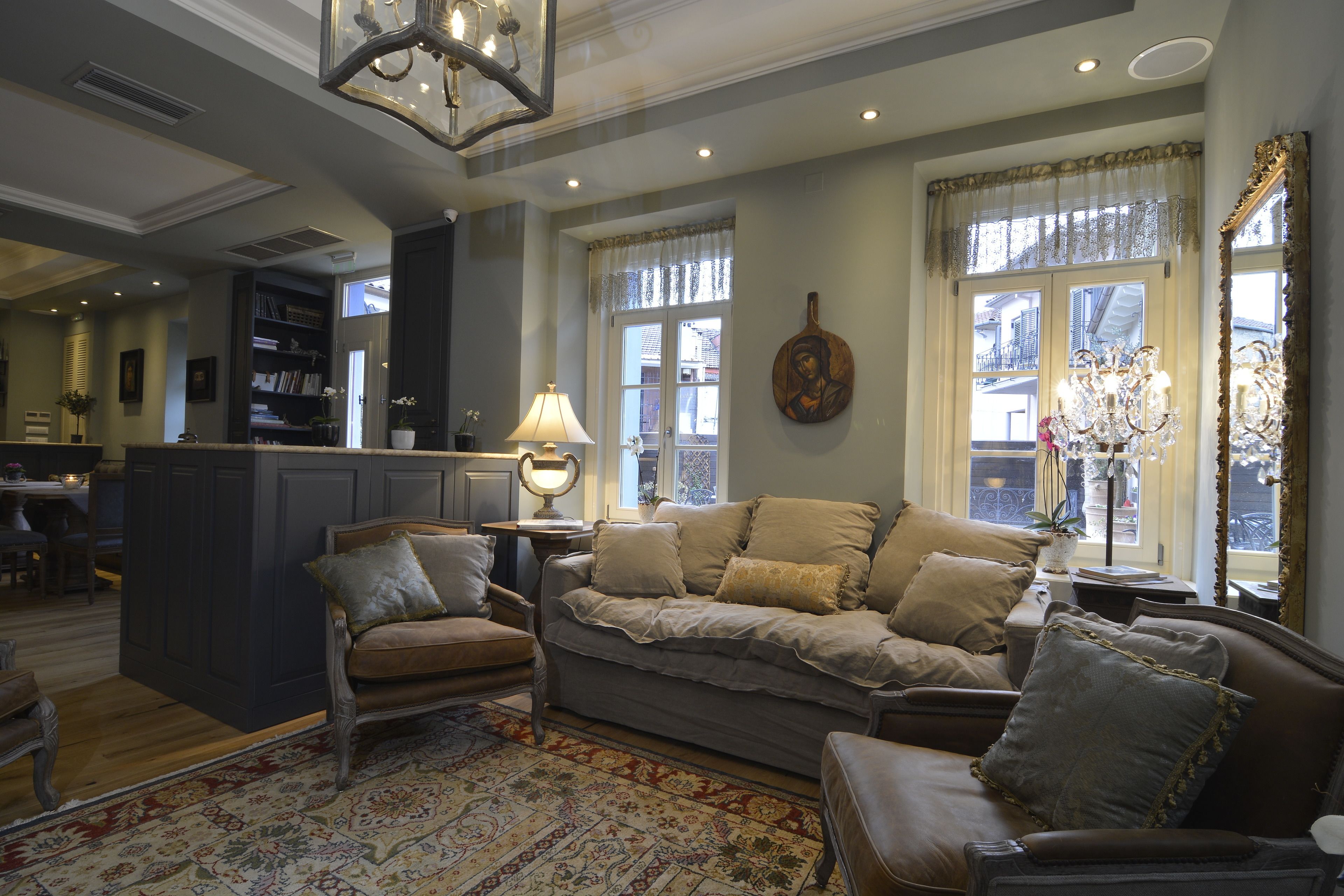 A cozy living room with a sofa, armchairs, and a patterned rug.