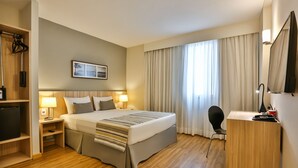 A hotel room with a bed, bedside lamps, a desk, and a chair. - Days Inn Rio de Janeiro, Lapa (Rio de Janeiro)