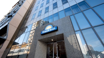 Fachada de um hotel Days Inn com fachada moderna em vidro e uma placa de destaque.