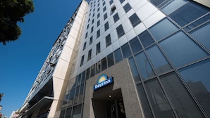 A modern building with a Days Inn sign, large glass windows, and a clear blue sky. - Days Inn Rio de Janeiro, Lapa (Rio de Janeiro)