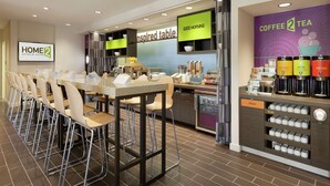 Eine Hotelhalle mit einer langen Rezeption, einer Kaffeebar und einem Mülleimer.