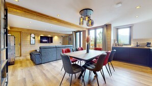 Una cocina moderna con comedor, vigas de madera y un amplio ventanal.
