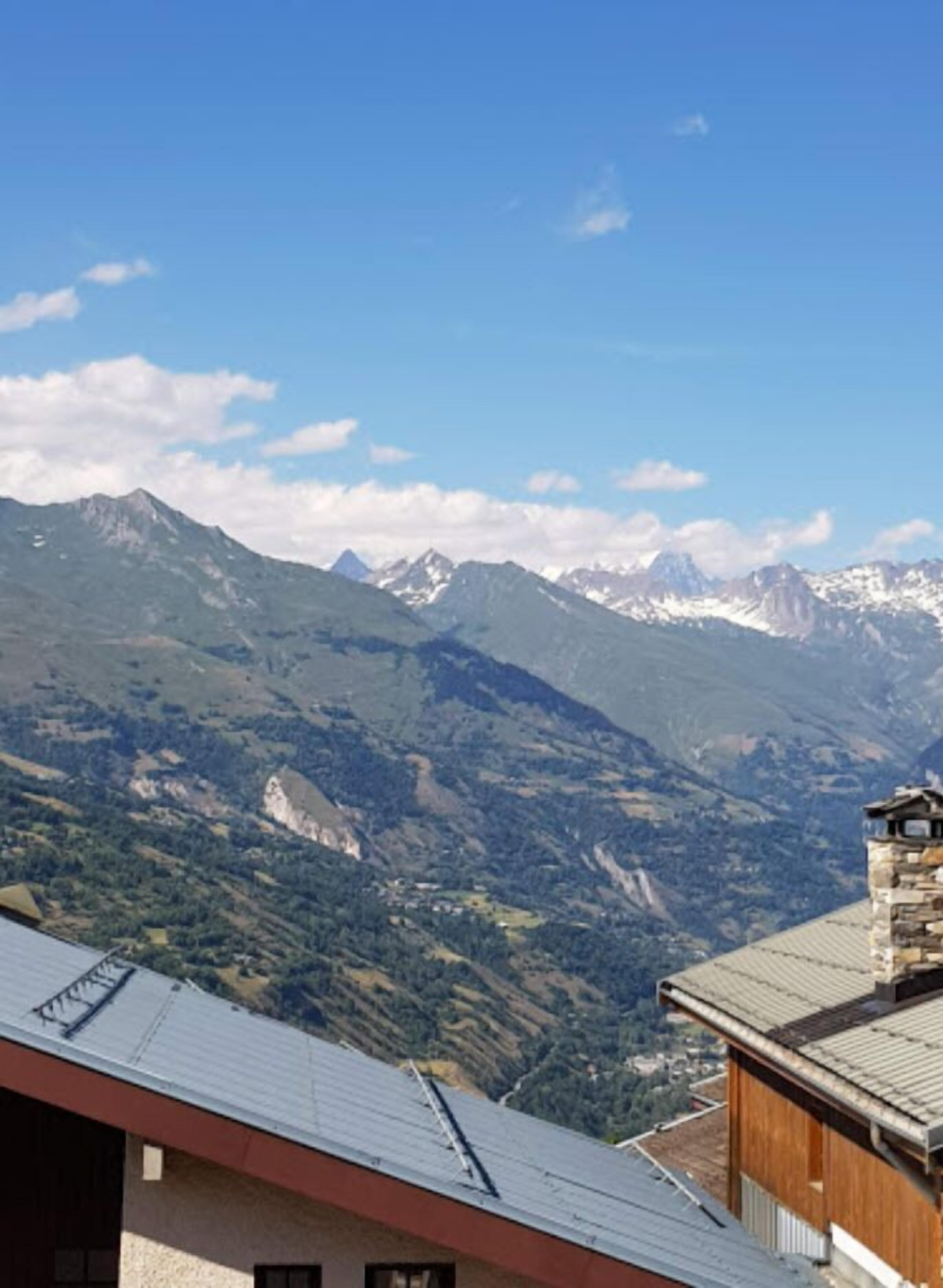 Vista de la montaña con un edificio de techo inclinado y paredes de piedra.