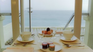 Una mesa preparada para el desayuno con vista al océano.