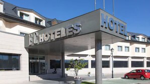 L’entrée d’un hôtel, avec une enseigne indiquant « HÔTEL » et une voiture rouge garée devant.