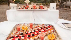 Une table dressée avec une variété de hors-d'œuvre et de boissons, probablement pour un buffet ou une fête.