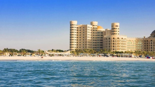 Een hotel aan de kust met meerdere torens, voorzieningen direct aan het strand en een zwembad.