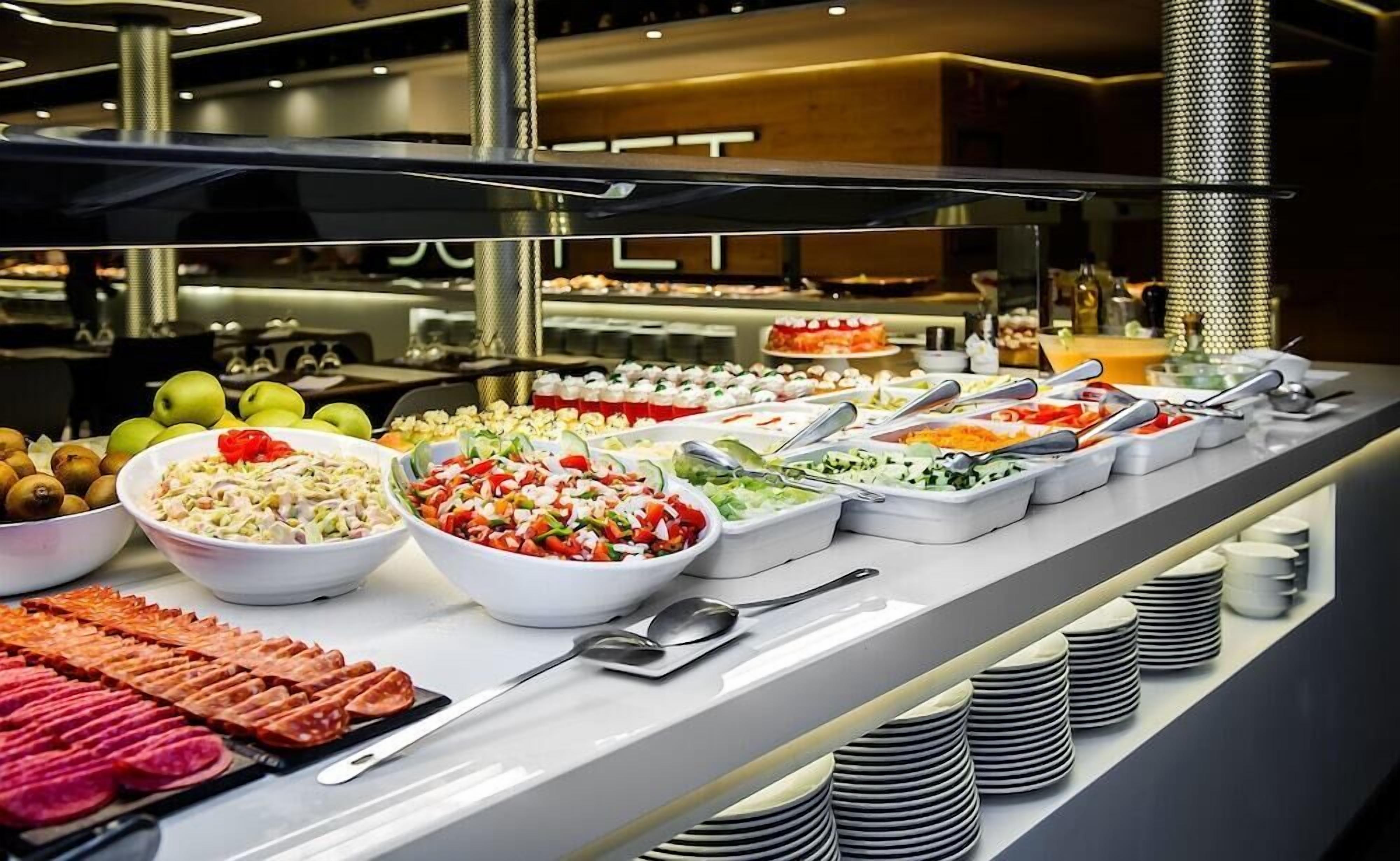 A buffet with various food items and utensils.
