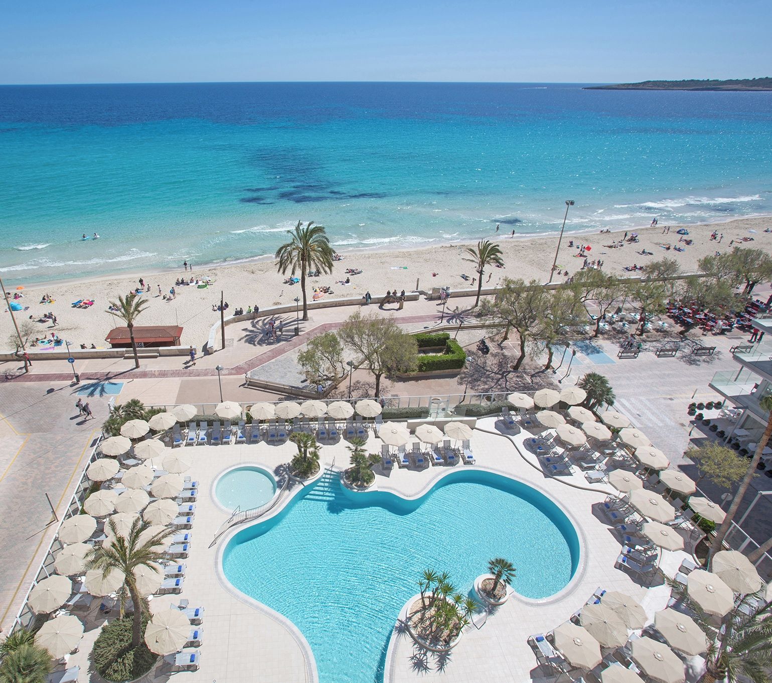 Un complexe hôtelier doté d’une piscine, d’une plage et offrant une vue sur l’océan.