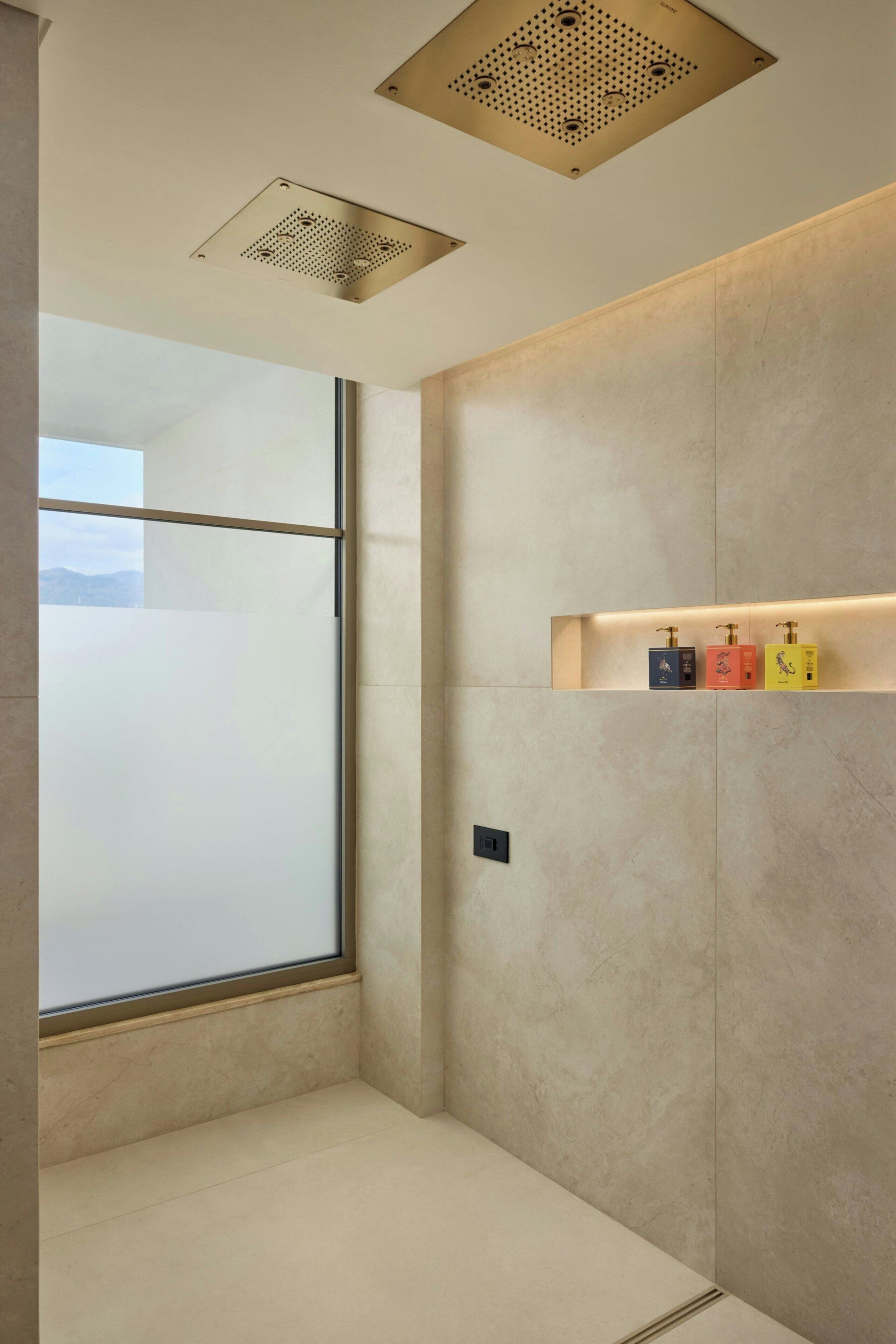 Een moderne badkamer met een groot raam, een douche en een plank met toiletartikelen.