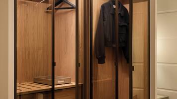 A walk-in closet with wooden paneling, a hanging rack, and a shelf with a storage box.