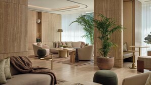 A modern living room with a sofa, armchairs, a coffee table, and a potted plant. - Principessa Forte dei Marmi, Autograph Collection (Forte dei Marmi)