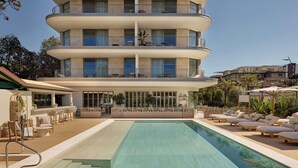 A multi-story hotel with a pool, outdoor seating, and balconies. - Principessa Forte dei Marmi, Autograph Collection (Forte dei Marmi)