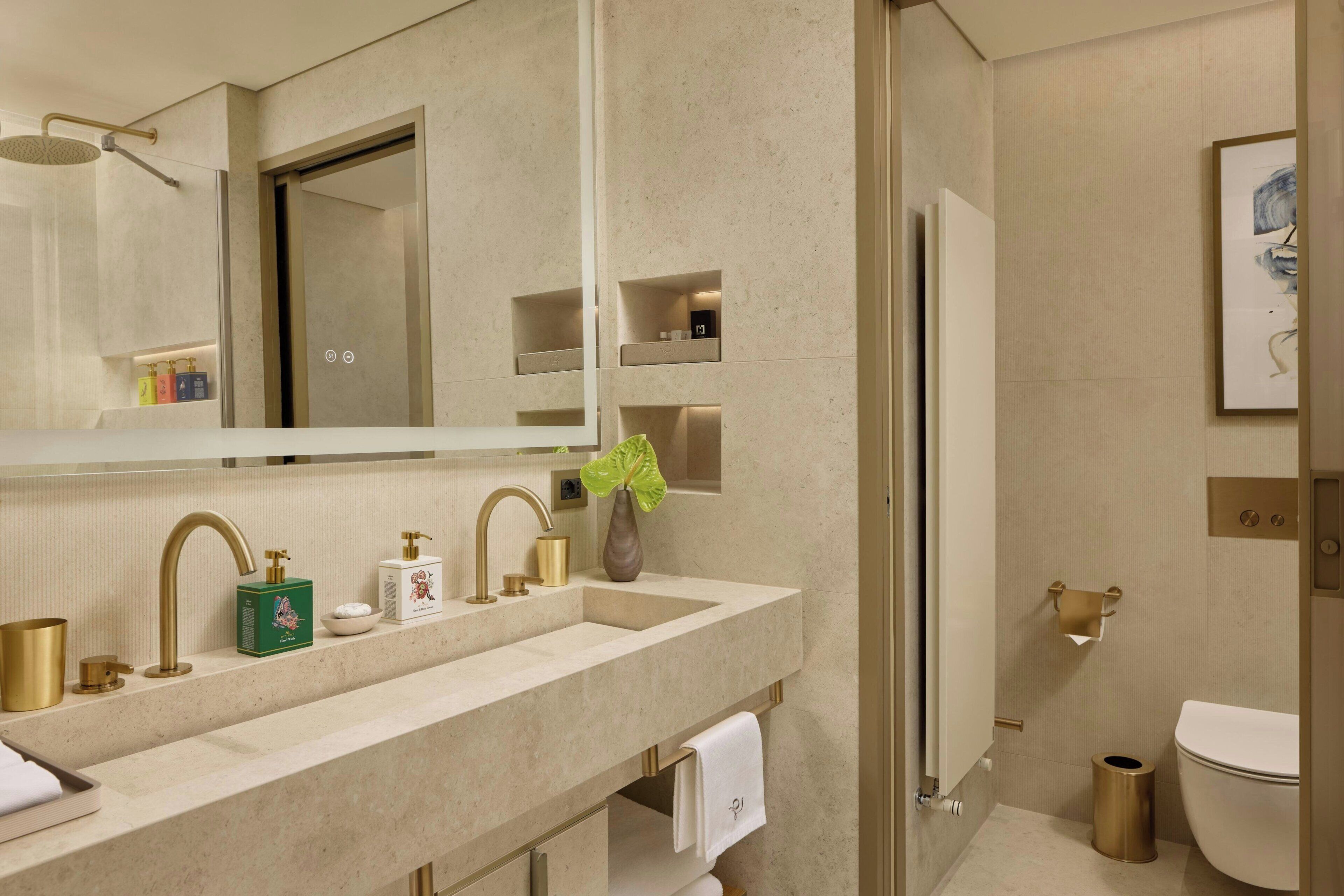 Un baño moderno con lavamanos doble, un espejo grande, ducha e inodoro.
