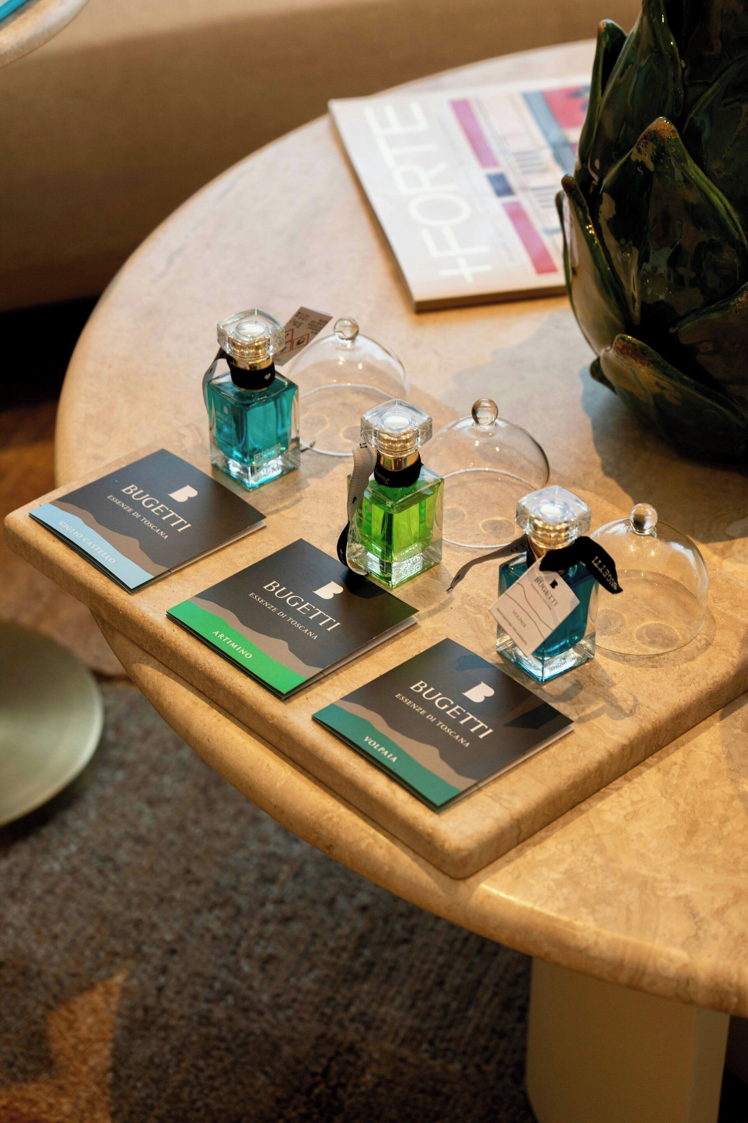 A display of perfume bottles on a table with labels and a magazine.