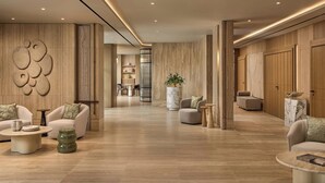 A modern hotel lobby with a central seating area, a marble column, and a large wall art piece. - Principessa Forte dei Marmi, Autograph Collection (Forte dei Marmi)