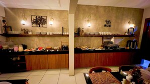 Una cocina moderna con una isla central, estantes integrados y un comedor con mesa y sillas.