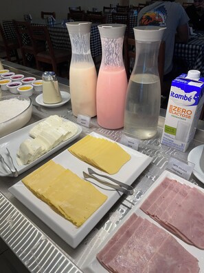 A buffet table with various dairy products, including yogurt, milk, and cheese. - Hotel Cantareira (Niteroi)
