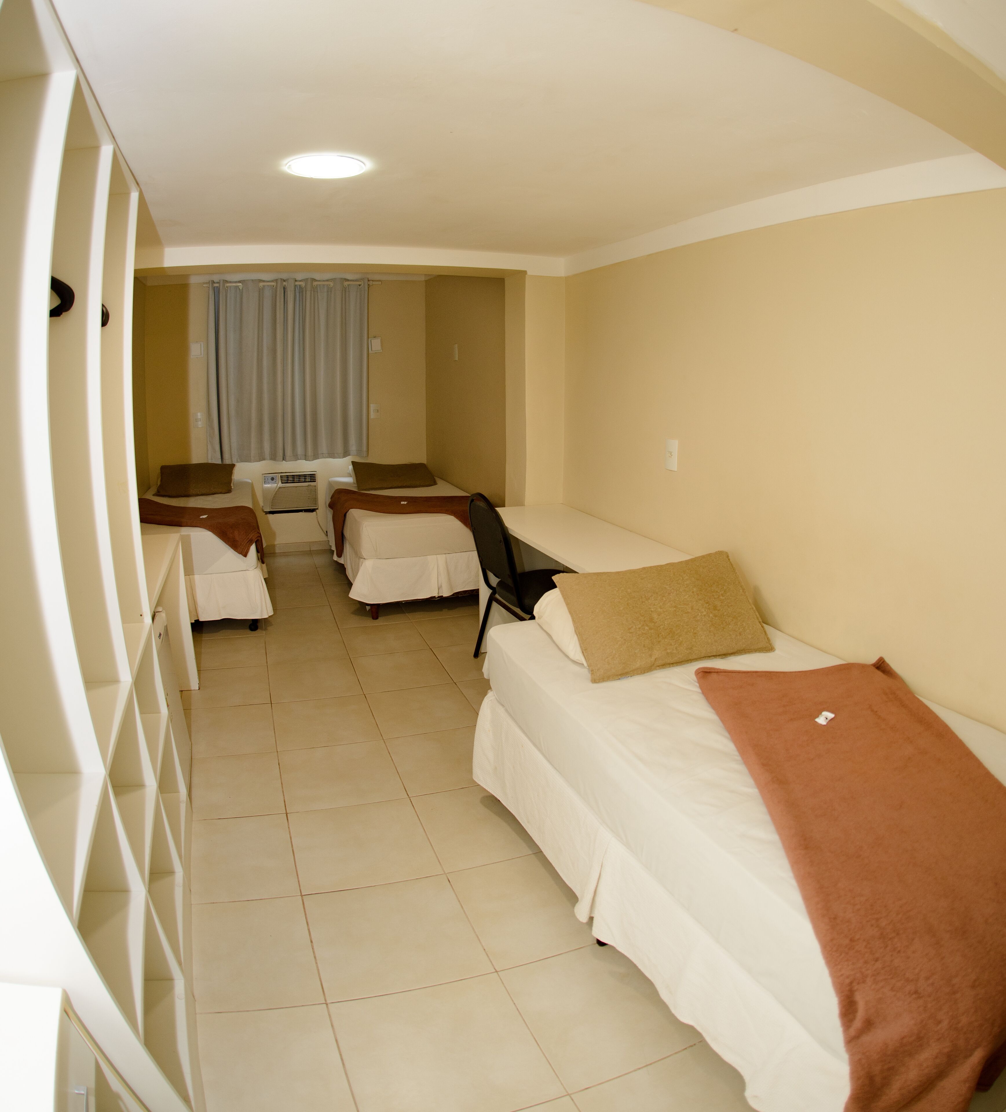 Una habitación de hotel con dos camas individuales, un escritorio y una silla.