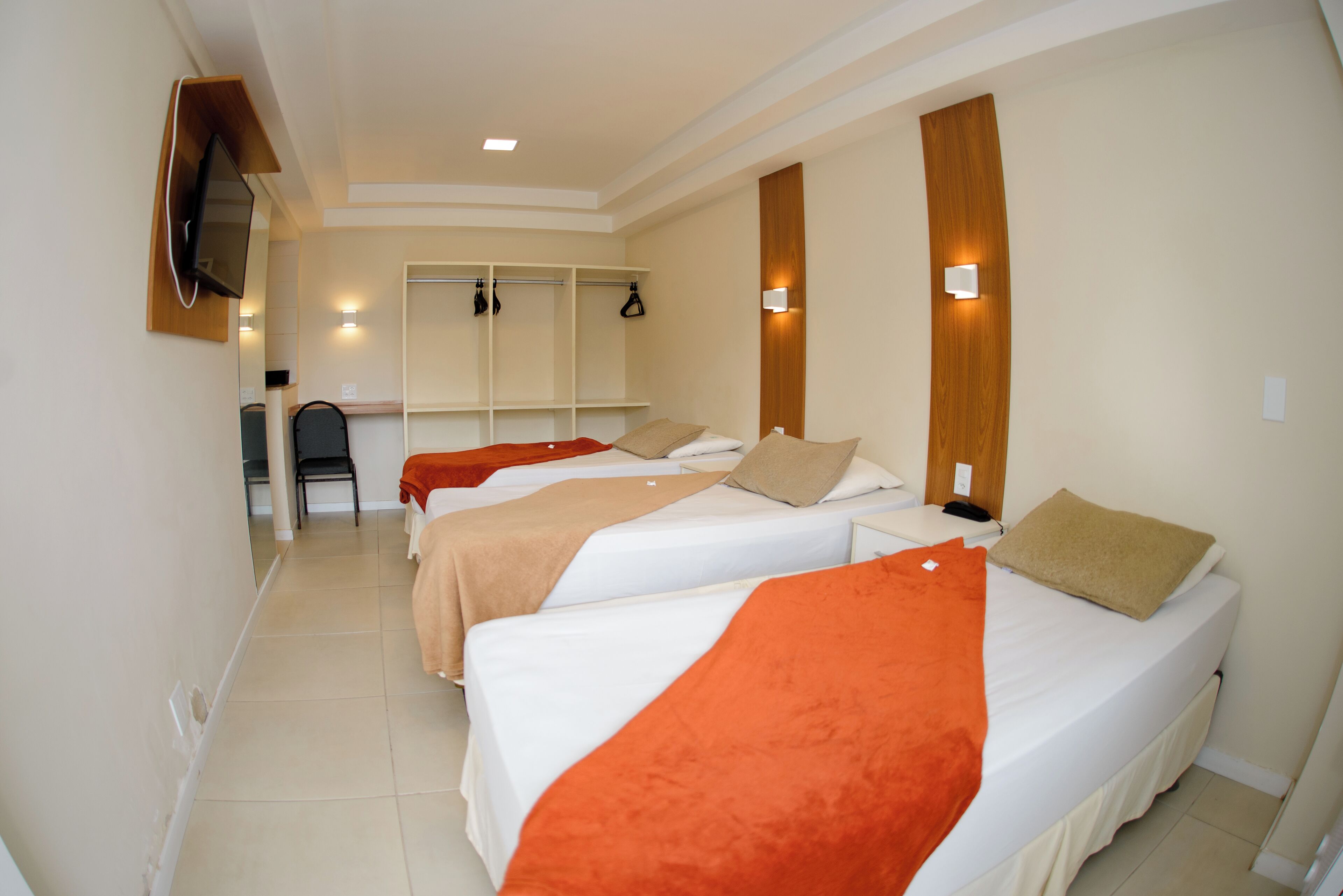 Ein Hotelzimmer mit zwei Betten, einem Schreibtisch und einem Stuhl.
