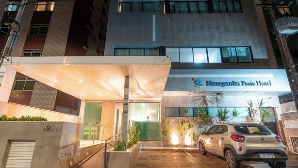 A modern hotel entrance with a covered area, a car parked in front, and a sign for 'Navegantes & Princes Hotel'. - Rede Andrade Navegantes (Recife)