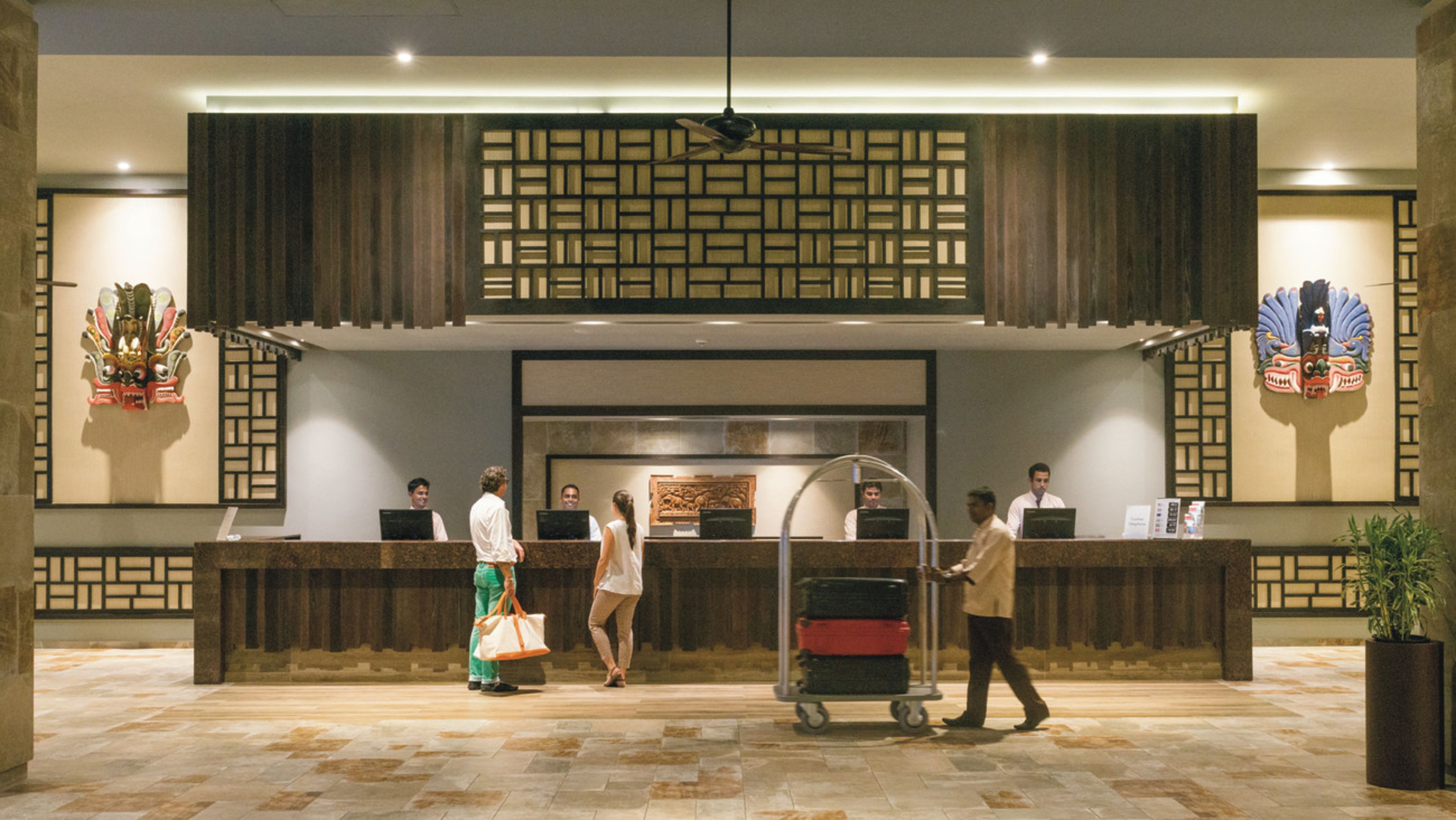 A reception area with a reception desk, a ceiling fan, and decorative wall panels.