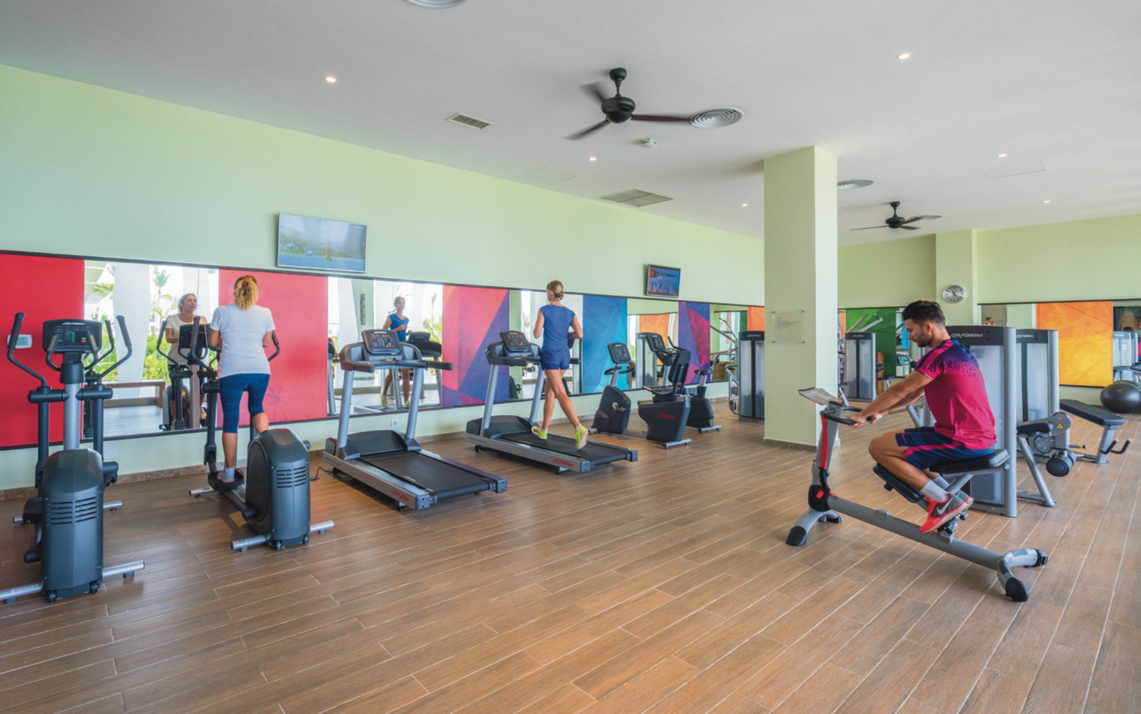 Uma academia com esteiras, bicicletas ergométricas e aparelhos de musculação.
