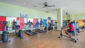 Uma academia com esteiras, bicicletas ergométricas e aparelhos de musculação.