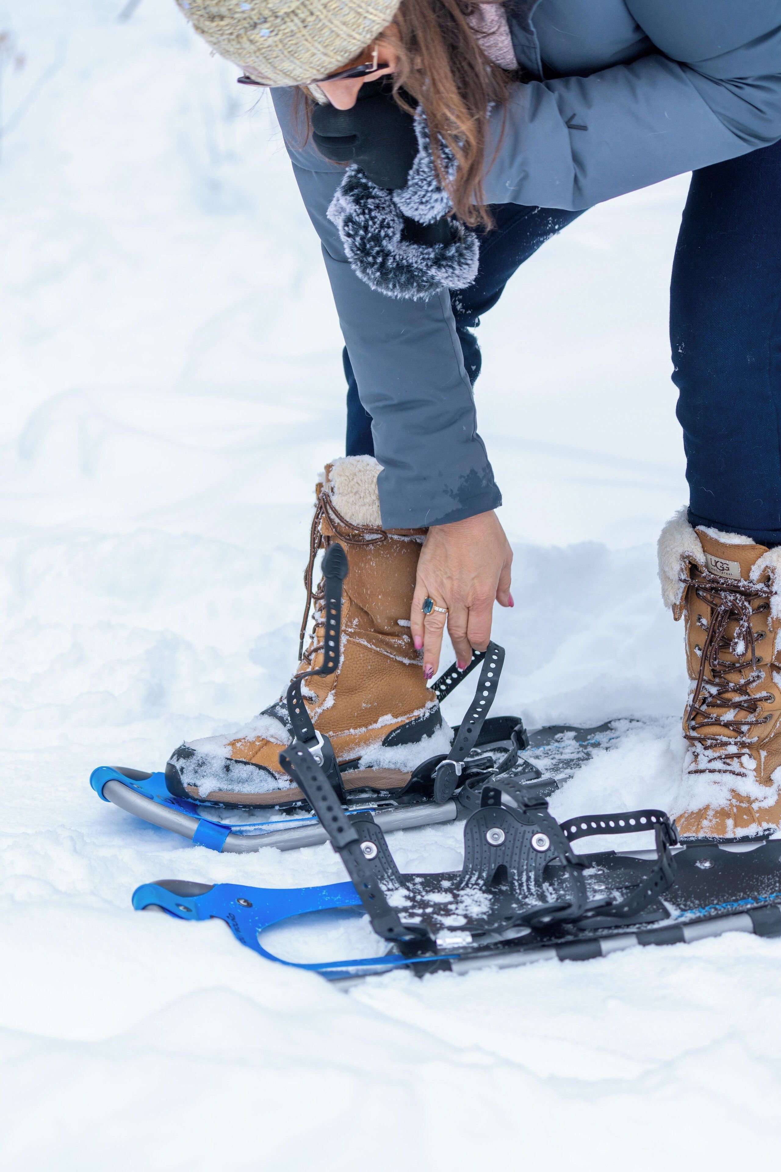 Una persona ajustant les raquetes de neu sobre un terreny cobert de neu.