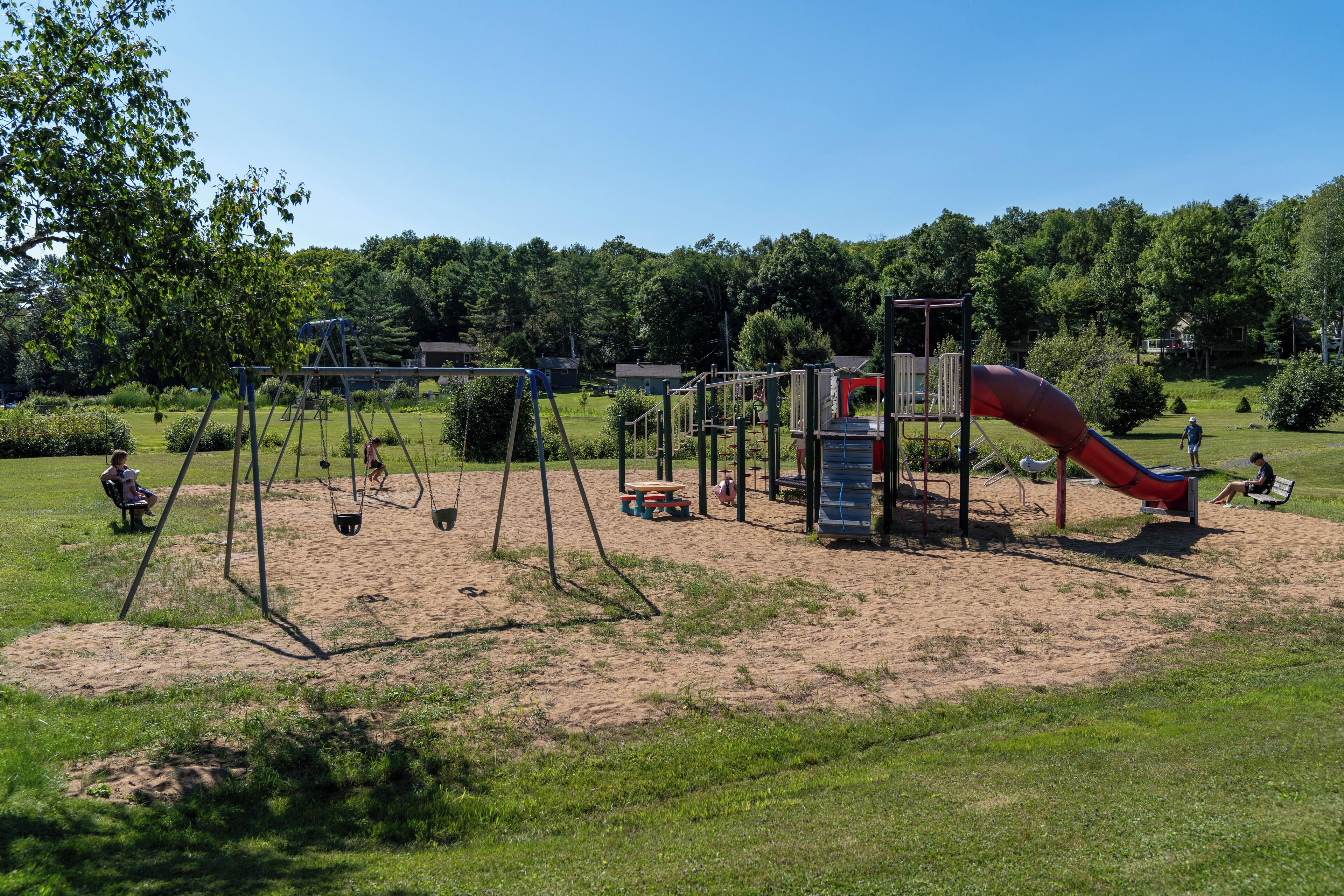 A playground with swings, a slide, and a climbing structure.
