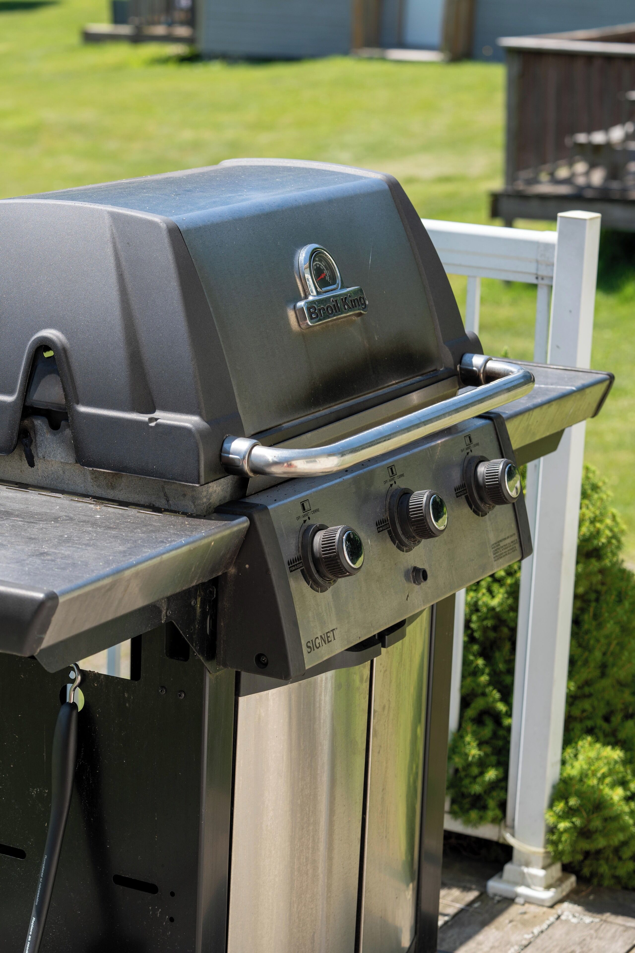 A stainless steel grill with a digital display and control knobs, mounted on a metal stand.