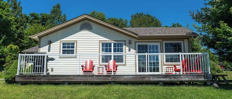 A single-story house with a fenced deck, two windows, and a small porch area.