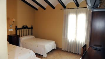 Un dormitorio con dos camas, un armario de madera, un escritorio y una ventana con cortinas.