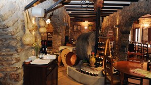 Una bodega rústica con paredes de piedra, barriles de madera y una estantería para vinos.