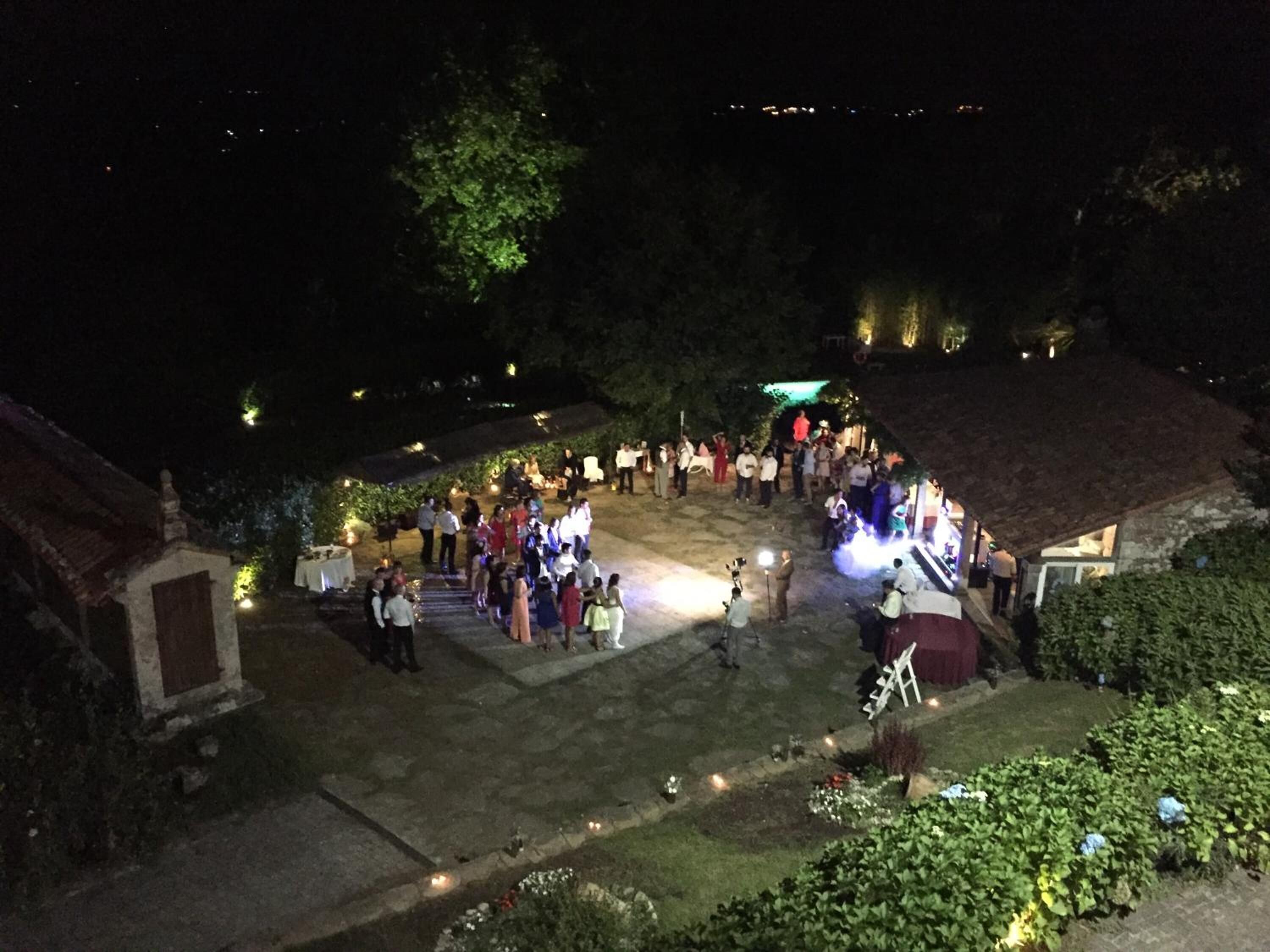 Un espacio al aire libre con escalones de piedra, rodeado de follaje y pequeñas luces.