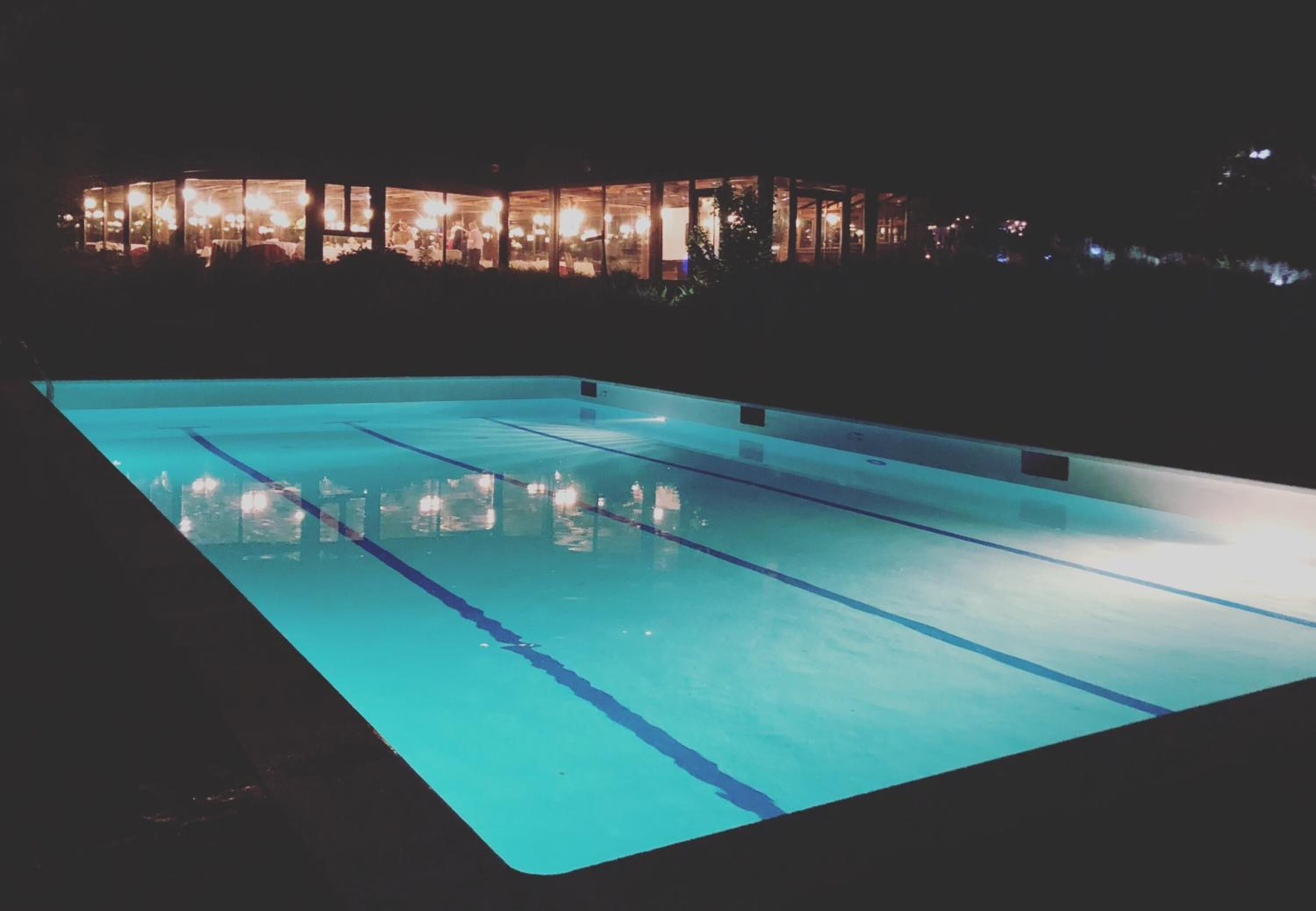 A swimming pool at night with lights reflecting on the water.