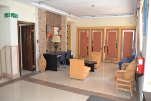 A lobby with a reception desk, seating area, and a fire extinguisher.