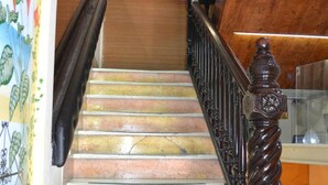 Un escalier avec une main courante en bois et une balustrade en verre, menant à un niveau inférieur.