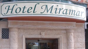 Un immeuble sur lequel on peut lire l’inscription « Hôtel Miramar » au-dessus de l’entrée.