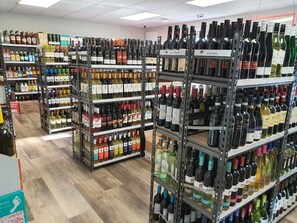 Passís de botiga amb prestatges plens de diverses ampolles de vi.