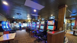 Ein Spielbereich mit mehreren Arcade-Automaten, einem Empfangstresen und einem Teppichboden.