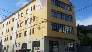 A multi-story hotel with a yellow facade, multiple windows, and a visible 'Hotel' sign. - Hotel Canabal (Burela)