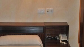 A hotel room with a bed, a wooden nightstand, and a telephone. - Hotel Canabal (Burela)