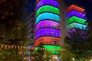 A multi-story building with balconies and a series of lights.