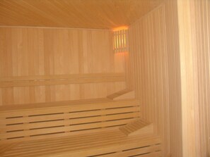 Una sauna con bancos de madera y asientos con listones.