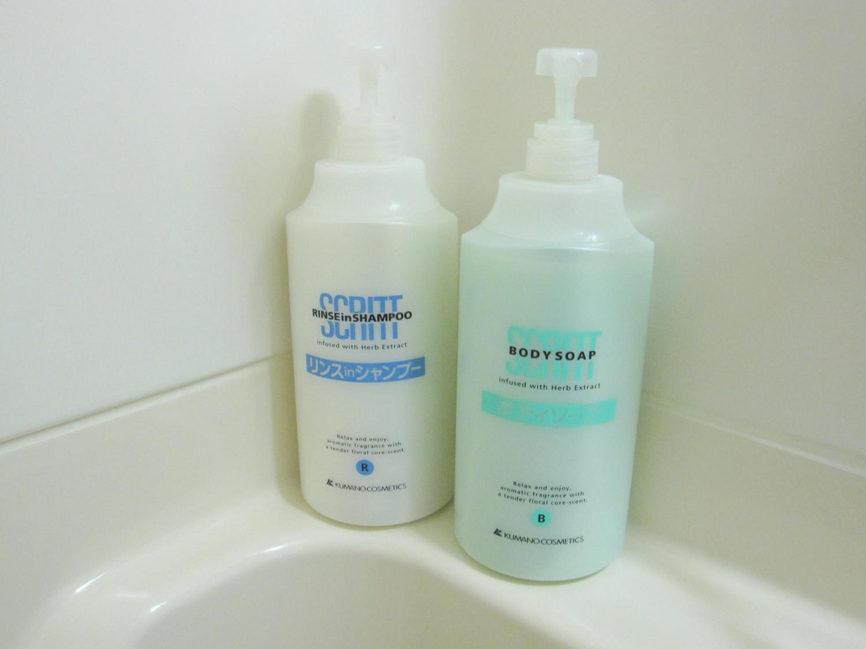 Dos botellas de jabón de baño y champú perfumados sobre una superficie blanca.