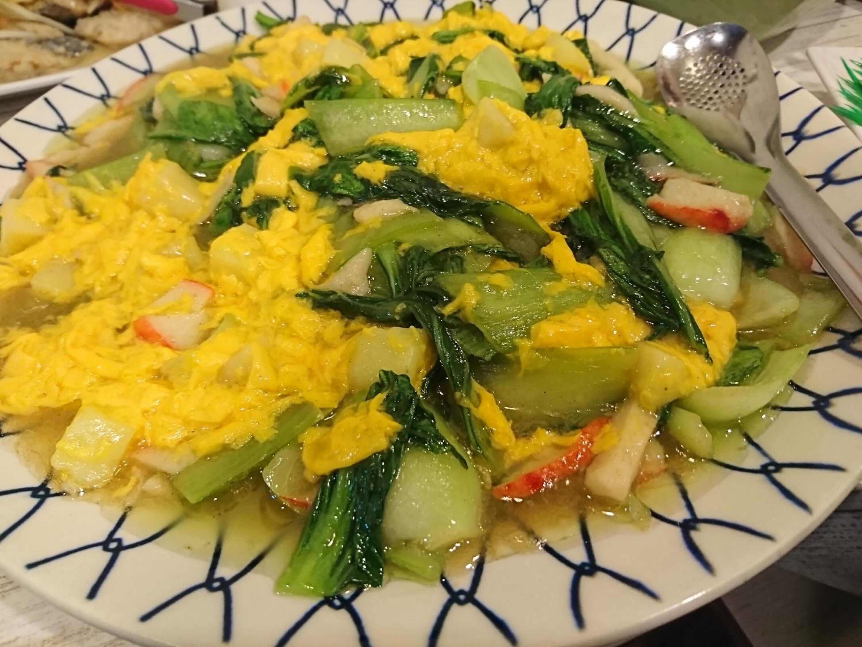 A plate of scrambled eggs with vegetables.