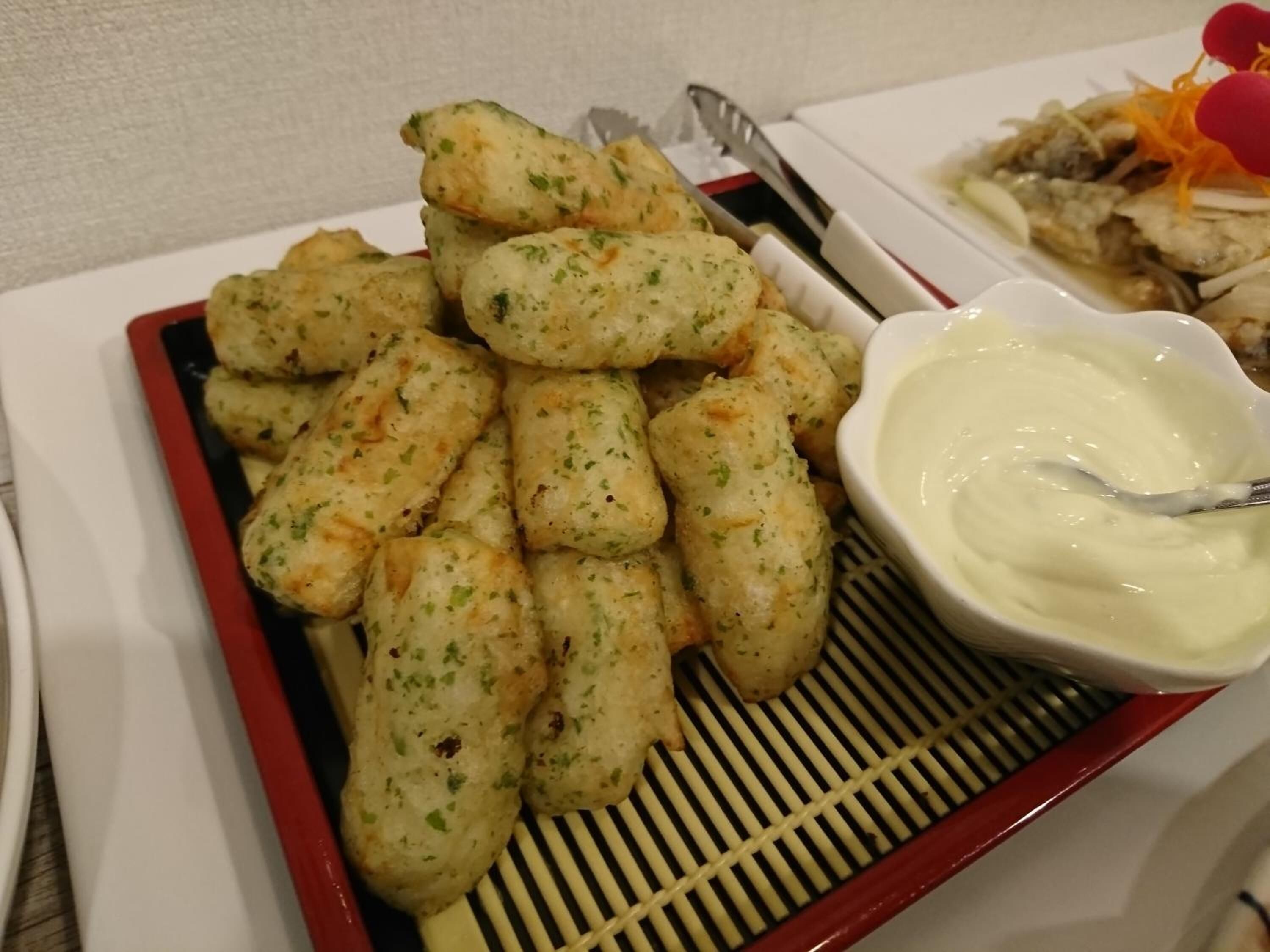 A plate of breadsticks with a dipping sauce.